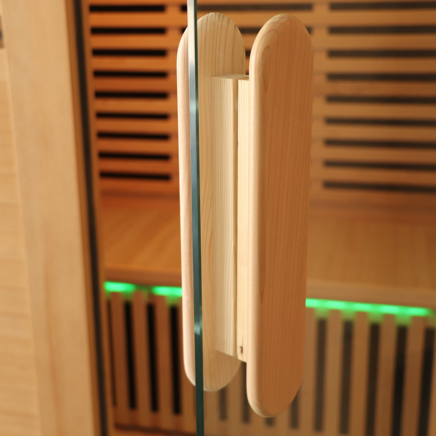 Wooden sauna door with a handle, partially open, revealing a green light inside.